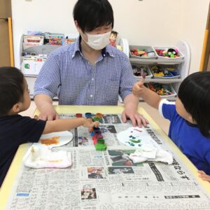 指についた絵の具を「見て！」と先生にお話しながら楽しそうに製作していました。