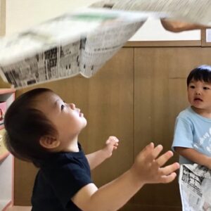 ひらひら舞う新聞紙を観察しているお友だち。