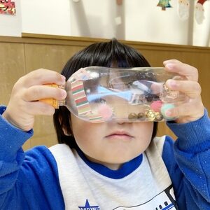 自分で作ったマラカスを見せる子ども