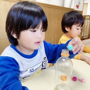 フェルトボールを容器に入れる子どもたち