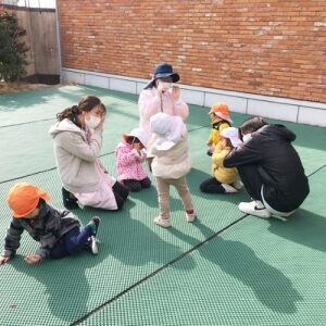 むっくりくまさんをして遊ぶ子どもと保育士