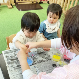 子どもに製作を指導する保育士