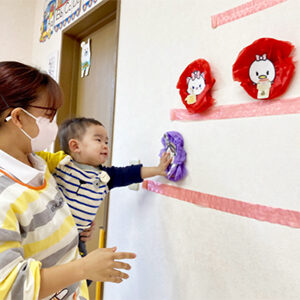 壁面のひな壇を飾る子ども