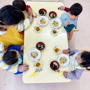 給食でひな祭りのお祝いメニューちらし寿司を食べる子どもたち