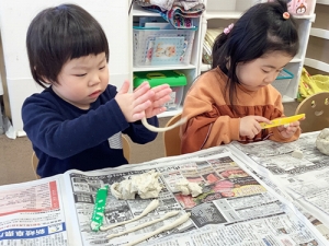 細い形状の粘土を作る子ども