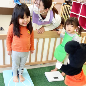 身長を測り笑顔を見せる子ども