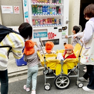 自販機を見ながらお話する子どもたちと保育士