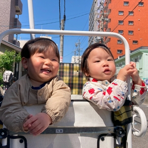 お散歩カートで笑顔を見せる2人の子ども
