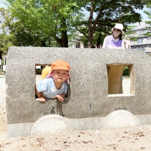 汽車の遊具の窓から顔を出す子ども