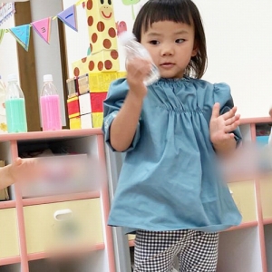 液体の入ったペットボトルを振る子ども