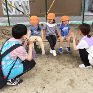 公園で話をする子どもたちと保育士