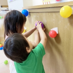 カラーボールで部屋を飾りつける子どもたち