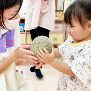 メロンを持ってにっこり笑う子ども