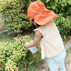 空き容器で木に水をやる子ども