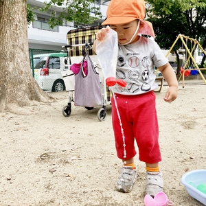 空き容器で水遊びをする子ども