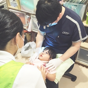 不安そうな顔で歯科検診を受ける子ども