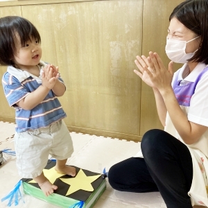 星の台に乗って拍手する子ども