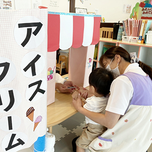 アイスクリーム屋さんで買い物ごっこをする子どもと保育士