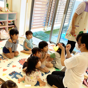 水遊び前に先生から約束事を聞く子どもたち