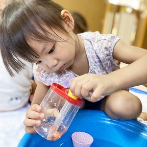 色のついた水で遊ぶ子ども