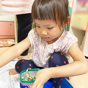 ペットボトルで作った容器を持って水遊びをする子ども