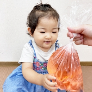 色水の入った袋を笑顔で持つ子ども