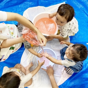 みんなで輪になって水遊びをする子どもたち