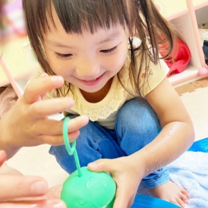 空き容器で水遊びをする子ども