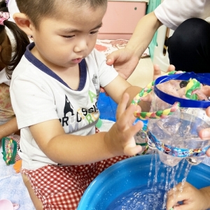 ペットボトルで作ったシャワーで遊ぶ子ども