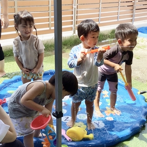 水鉄砲などで水遊びをする子どもたち