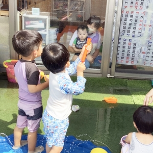 お部屋にいる先生たちに水鉄砲で水をかける子ども