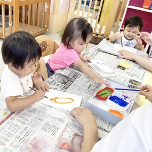 指や筆で色を塗る子どもたち