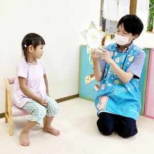 誕生日の子どもと手形を見せる保育士