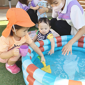 プールの水を触る子どもたち