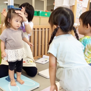 お友だちの身長測定を見守る子どもたち