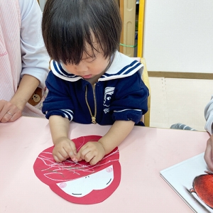 達磨の胴に色を塗る子ども