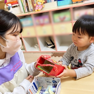 空き箱で作ったバッグを手にする子ども