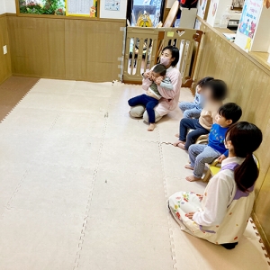 みんなで並んで座り英語のオンラインレッスンを受ける子どもたち