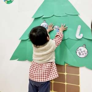 クリスマスツリーに飾りをつける子ども