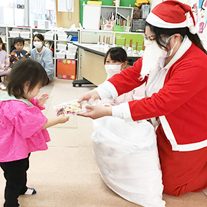 サンタクロースからプレゼントを受け取る子ども