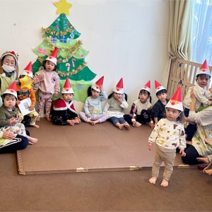 サンタクロースが描かれた三角帽子を被ってクリスマス会に参加する子どもたちの様子