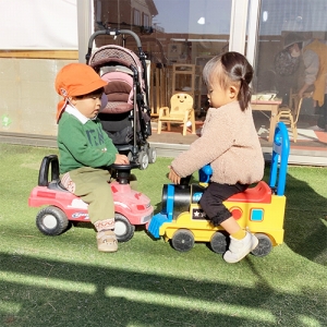 幼児用の車で遊ぶ子どもたち