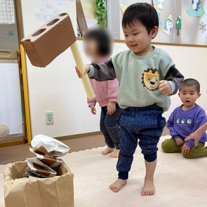 手作りの杵と臼でお餅つきをする子ども