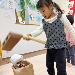 手作りの杵と臼でお餅つきをする子ども