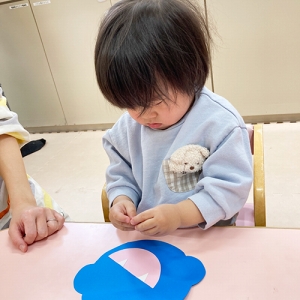 鬼の顔のパーツを貼り付ける子ども