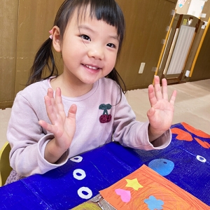 チョコレートの壁面製作を作って笑顔を見せる子ども