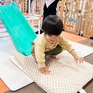 室内の滑り台を滑りおりる子ども