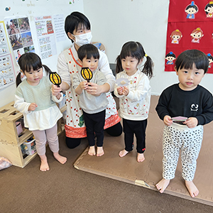 ひな飾りを手に持つ子どもたち