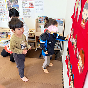 壁面のひな壇にひな人形を飾る子どもたち