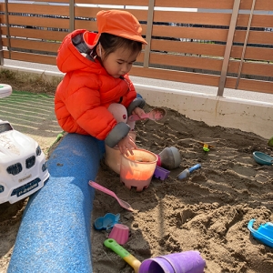 砂でケーキを作る子ども